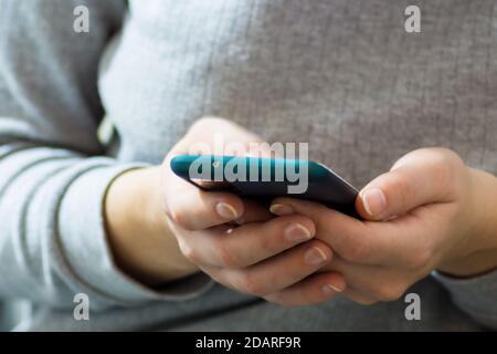 Frontal view of woman’s beautiful hands using the smartphone Stock Photo