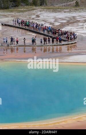 Visitors walk along the boardwalk at Grand Prismatic Spring in Yellowstone National Park, Wyoming on Monday, August 3, 2020. Many of the parks boardwa Stock Photo