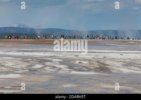 Visitors cue up along the boardwalk at Grand Prismatic Spring in Yellowstone National Park, Wyoming on Monday, August 3, 2020. Many of the parks board Stock Photo