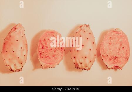 Fichi di India, cactus fig fruits or prickly pear of Opuntia, fresh ripe figs in a row in pastel colors Stock Photo