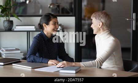 Happy diverse colleagues chatting during break, having pleasant conversation Stock Photo