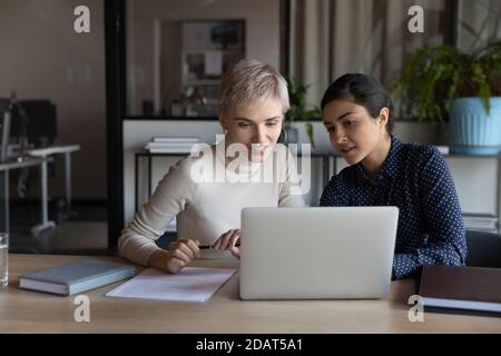 Smiling diverse colleagues businesswomen working on laptop together Stock Photo