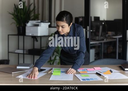 Confident Indian businesswoman working with project documents, colorful stickers Stock Photo