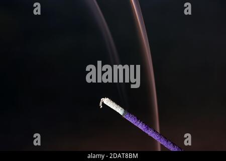 Closeup shot of an incense stick on a blurry background Stock Photo
