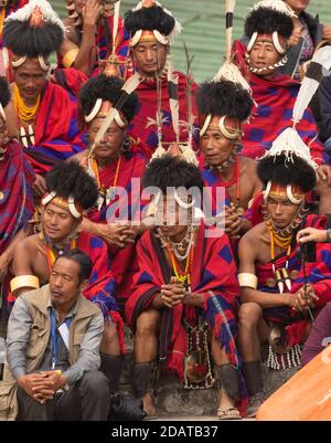 A group of Naga tribesmen siting wearing their traditional attire iat a Village in Nagaland India on 4 December 2016 Stock Photo