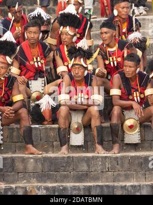 Naga tribesmen  wearing their traditional attire and siting together in Kisama Village arena  in Nagaland India on 4 December 2016 Stock Photo