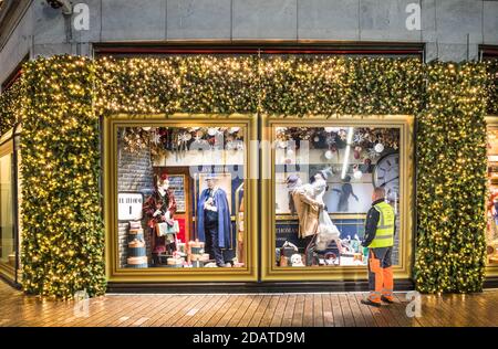 Cork City, Cork, Ireland. 15th November, 2020. A Cork City Council worker looks at the Christmas window on a theme of train travel at Brown Thomas in Patrick's Street, Cork, Ireland.  - Credit; David Creedon / Alamy Live News Stock Photo