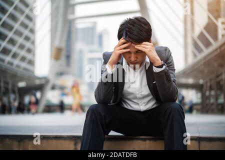 stressed business man sitting on the floor in the city Stock Photo