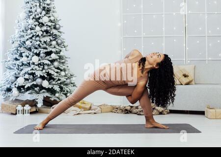 Beautiful young woman practices yoga asana Virabhadrasana at the yoga class. Stock Photo