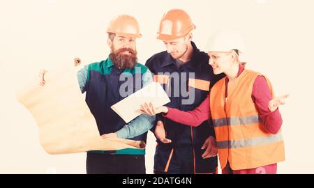 Team of builder, engineer, architect arguing about project. Misunderstanding concept. Men and woman in helmets, architects on busy faces looks at drawing, plan, blueprint, project, white background. Stock Photo