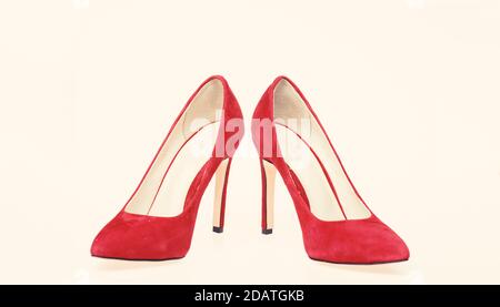 Shoes made out of red suede on white background, isolated. Footwear for women with thin high heels. Elegant stiletto shoes concept. Pair of fashionable high heeled pump shoes. Stock Photo