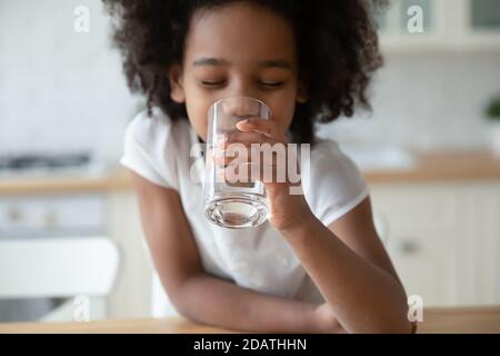 Close up head shot African American little girl drinking water Stock Photo