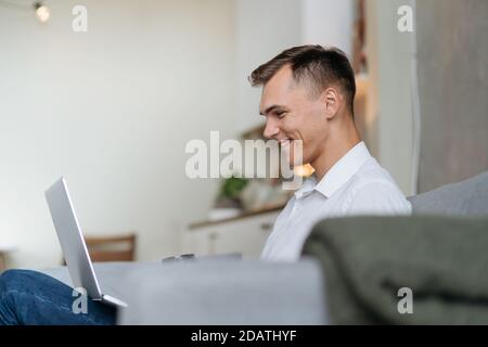 young man with a takeaway coffee reading his email . Stock Photo