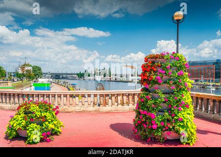 Flower decoration on Long Bridge, called Most Dlugi and view on Wieleckie Quay in Szczecin, Poland. Promenade and boulevards on Odra River embarkment Stock Photo