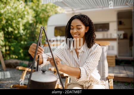 Woman cooking near the rv, camping in a trailer Stock Photo