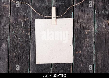Empty blank on rope with clothespin, old wooden background Stock Photo