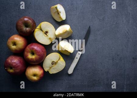 Red and yellow apples on a table. Grey background with copy space. Healthy eating concept. Stock Photo