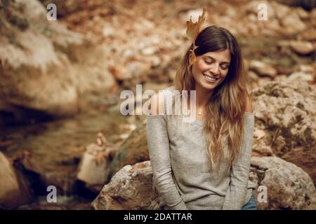 Portrait of a Nice Female with Dry Maple Leaf Behind the Ear. Happy Positive Vibes. Girl Enjoying Nature. Beauty of the Fall. Stock Photo