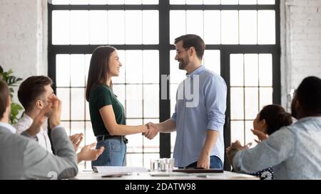 Glad male leader congratulating happy female employee with professional achievement Stock Photo