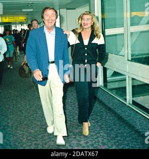 Des O'Connor with his wife Jodie Brooke Wilson at London Heathrow Airport 1992 Stock Photo