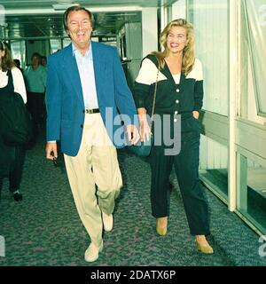 Des O'Connor with his wife Jodie Brooke Wilson at London Heathrow Airport 1992 Stock Photo