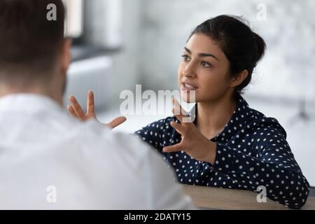 Inspired young indian female describing idea to business partner Stock Photo