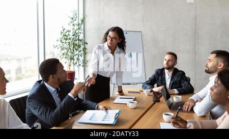 Businesswoman On Business Meeting Talking With Colleagues Standing In Office Stock Photo