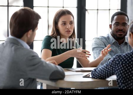 Two diverse groups of business partners sitting at negotiation table Stock Photo