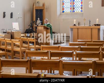 A priest preaches to an empty church during lockdown, the congregation is following on Zoom and Facebook Stock Photo