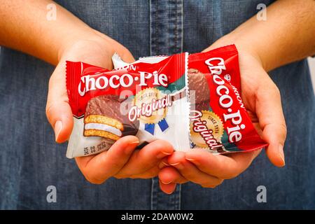 Tambov, Russian Federation - October 30, 2020 Orion Choco-Pie snack cakes in woman hands. Stock Photo
