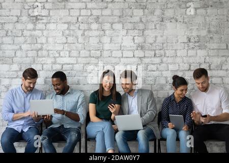 Group of diverse multiethnic young people sharing information using wifi Stock Photo