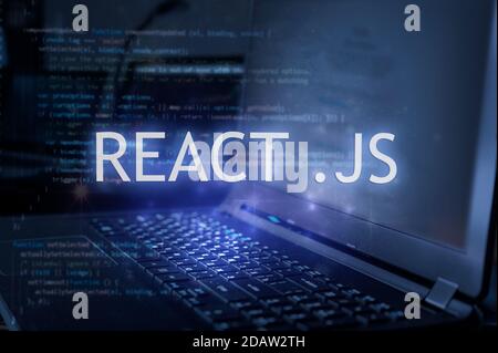 React .js inscription against laptop and code background. Learn react programming language, computer courses, training. Stock Photo