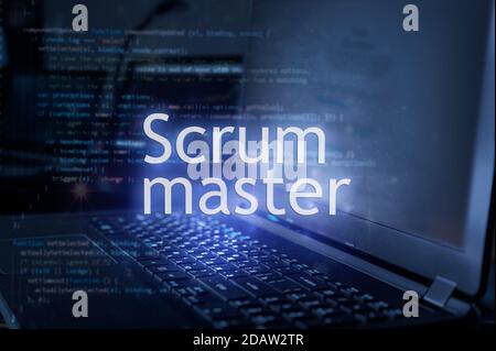 Scrum master inscription against laptop and code background. Scrum is facilitated by a scrum master. Stock Photo