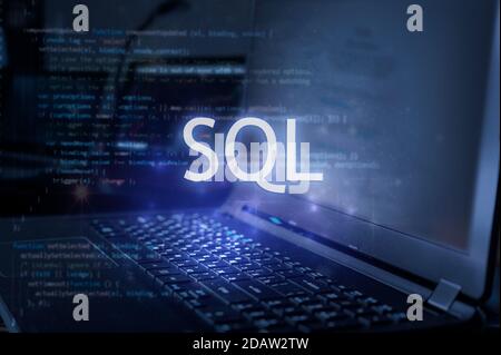 SQL inscription against laptop and code background. Learn sql programming language, computer courses, training. Stock Photo