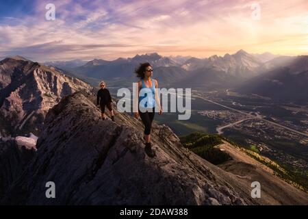 Adventurous Girl is hiking up a rocky mountain. Stock Photo