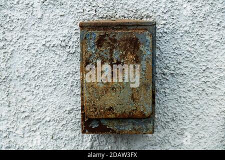 old rusty mailbox hanging on stone texture wall Stock Photo