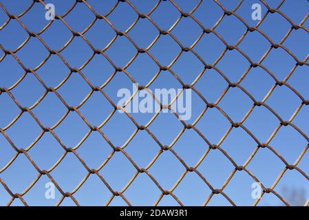 Metallic fence net against the sky Stock Photo