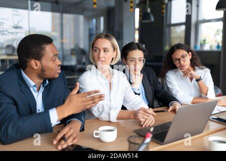 Colleagues On Business Meeting Discussing Project Sitting In Modern Office Stock Photo