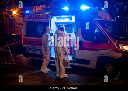 Napoli, Italy. 14th Nov, 2020. A suspected Covid-19 case (R) seen while entering in the ambulance.On October 14th, an ambulance for a suspected case of Covid-19 was seen in the trendy Vomero district in Naples. The rapid increasing of Covid19 cases caused an overflow of people to local hospitals thereby the inclusion of Naples and Campania region in the high risk zone (red-zone), which starts on November 15th. Credit: SOPA Images Limited/Alamy Live News Stock Photo