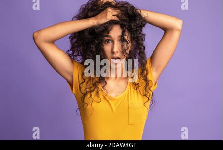 Bad Hair Day. Crazy Young Woman Touching Head And Looking At Camera Stock Photo