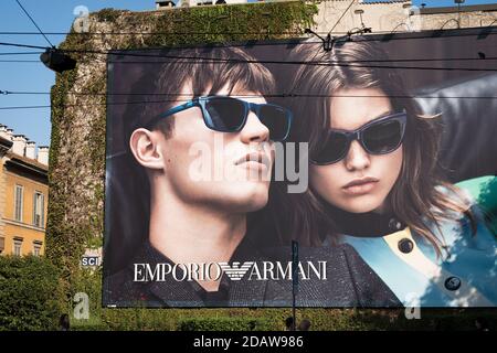 Advertising billboard of the Emporio Armani in Milan downtown, with two models with glasses. Italian company was founded by designer Giorgio Armani. Stock Photo