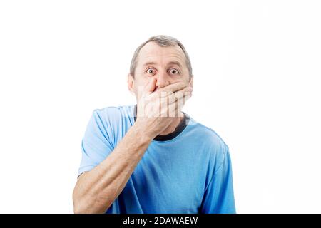 Shocked middle aged man with wide opened eyes covering his mouth with his hand isolated on white background with copy space. Surprised business middle Stock Photo
