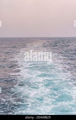 Water surface background. Blue sea water splashes with sun reflections. Ripples of water in the.