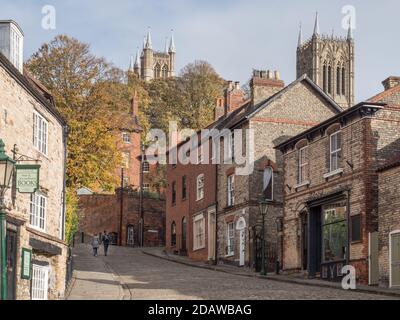 Looking up LIncoln's Steep Hill, a medieval old city touristic attraction on quiet day with 2 people Stock Photo
