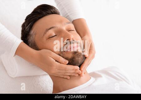 Spa therapist making relaxing massage for handsome man Stock Photo