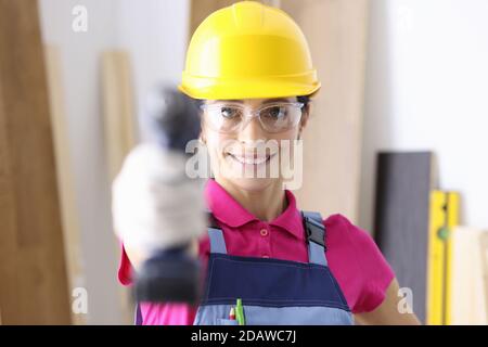 Smiling female builder holding a drill closeup Stock Photo