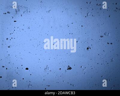 Concrete wall with irregularities painted with blue paint. Abstract building surface background. Stock Photo