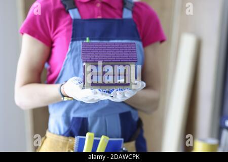 Builder holds the house in his hands. Stock Photo