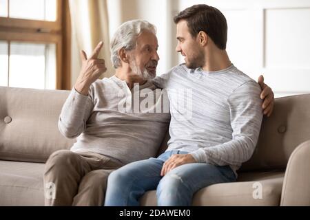 Happy older father and son having pleasant conversation at home Stock Photo