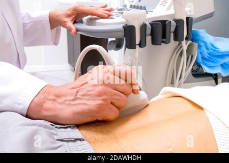 Adult doctor diagnoses human kidneys using ultrasound. Urologist Stock Photo